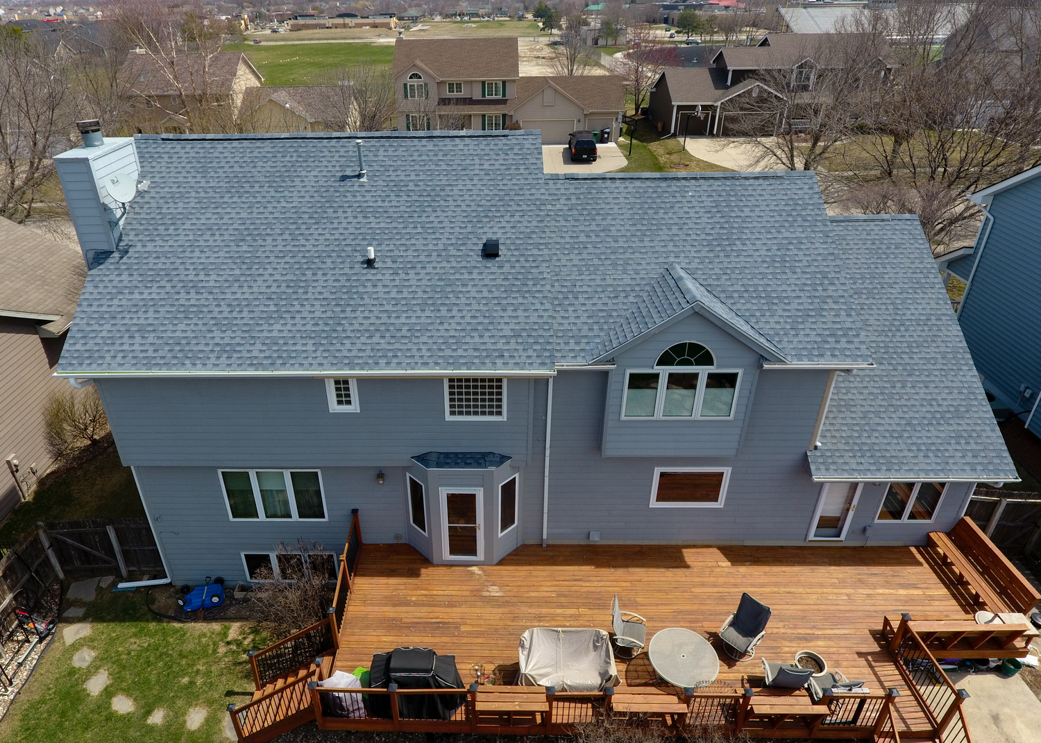 Aerial view of an Andrew's Roofing Company crew installing a new shingle roof on a home.