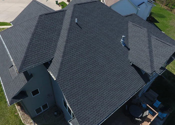 Weathered asphalt shingle roof on an Iowa home showing signs of age and granule loss